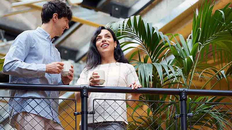 A man and woman holding coffee mugs