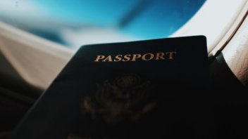 US passport with airplane window in background