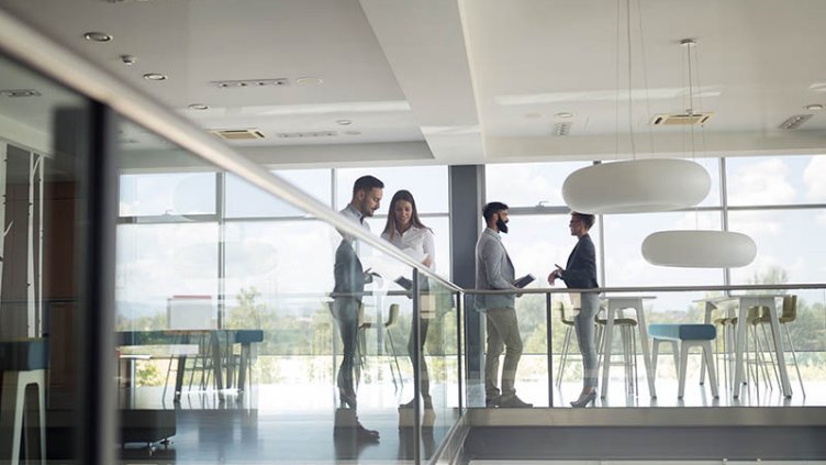 Group of business people walking and taking at stairs in an office building