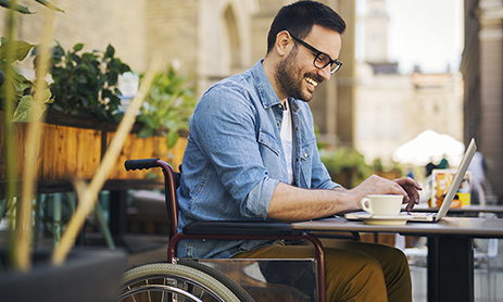 A person on a wheelchair and working on laptop