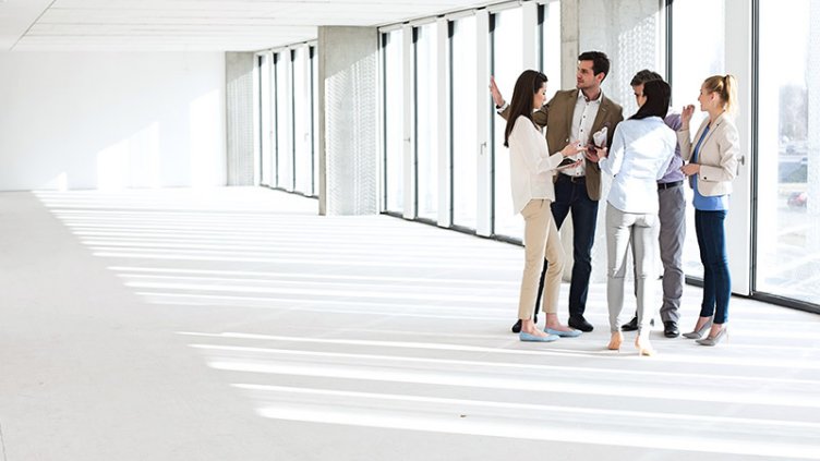 Full length of business people having discussion in empty office space