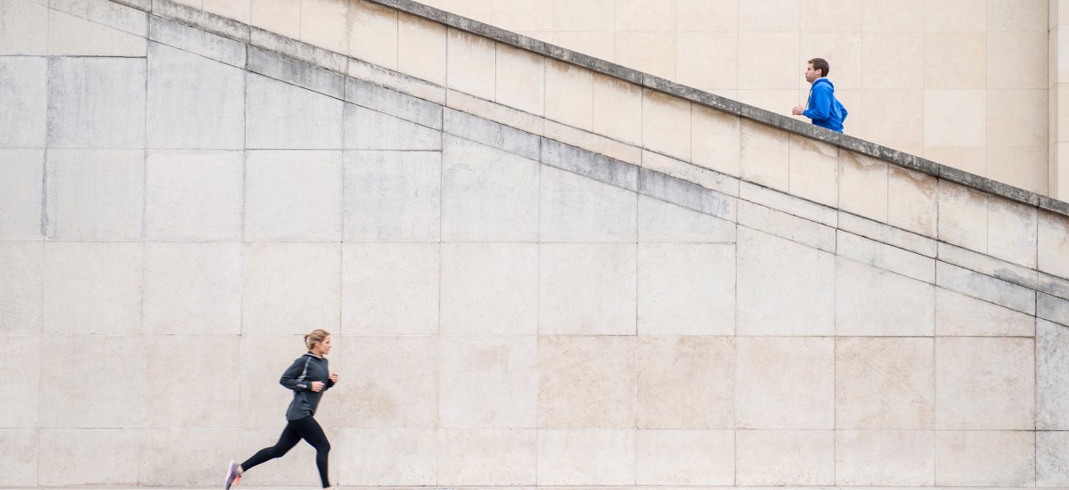 Caucasian runners jogging near staircase