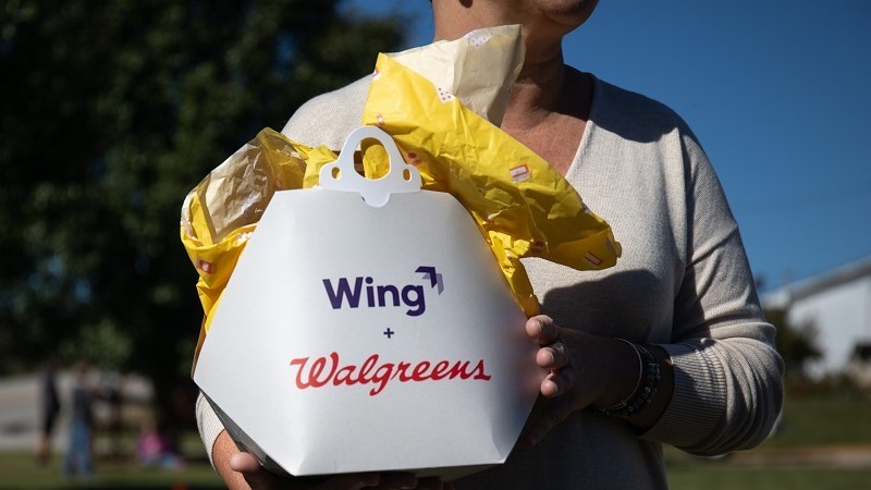 woman carrying wing walgreen package