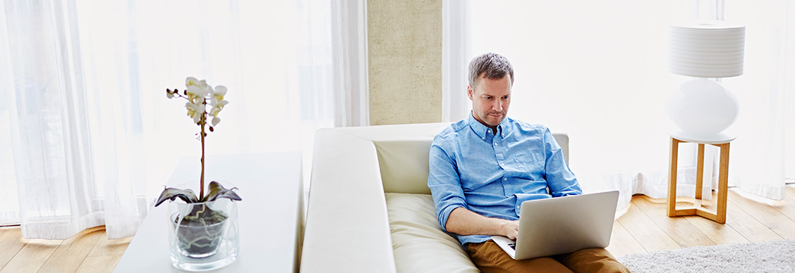 A man working while sitting on Sofa