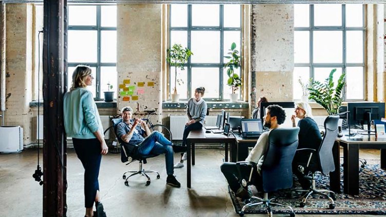 Group of colleagues communicating in a hybrid workspace