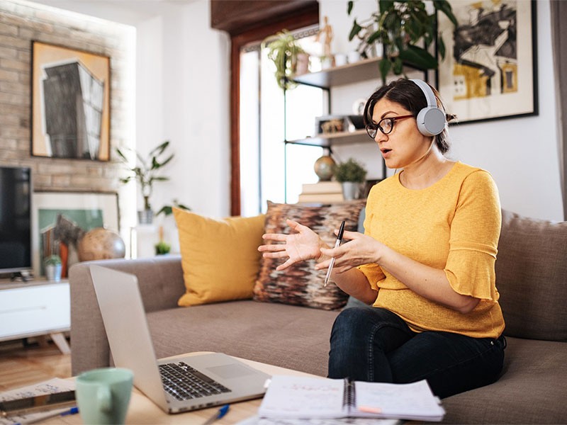 Woman working remotely from home and having a conversation with her colleague in a virtual meeting