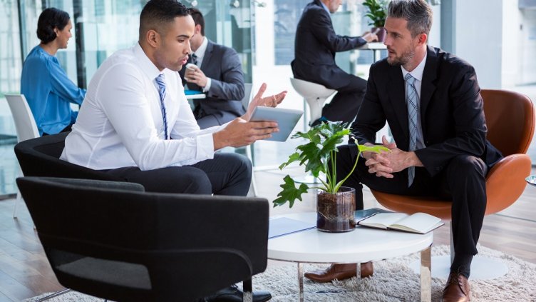 Businessmen having discussion over digital tablet in office