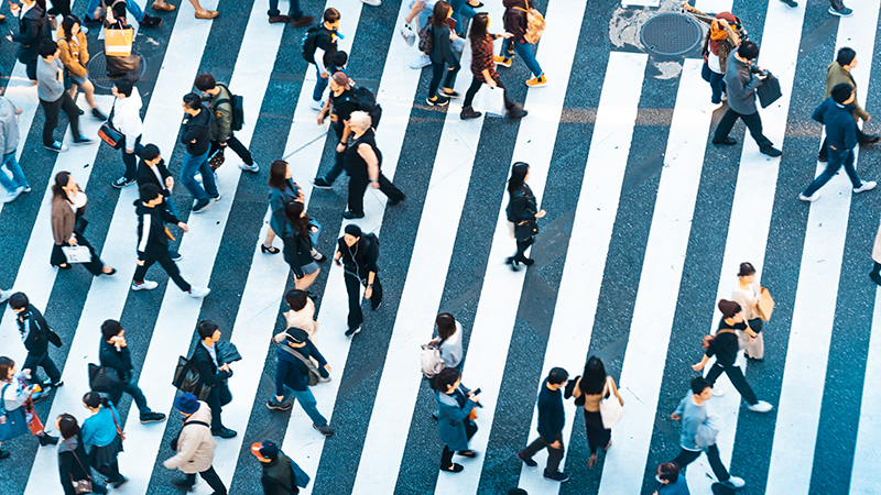 People walk across an urban cross-walk