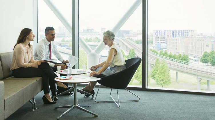 Investors discussing about the gig economy while sitting inside a real estate office building