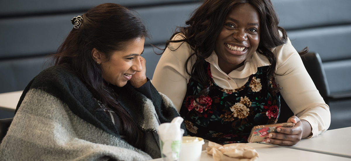 two women interacting with smart phone