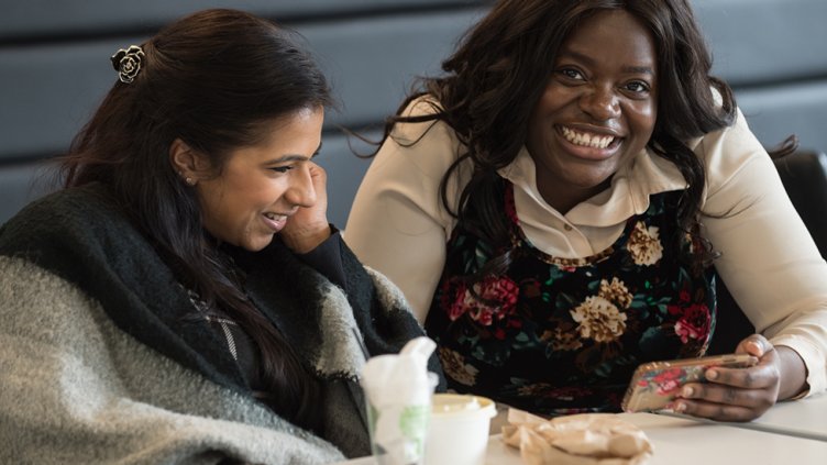 two women interacting with smart phone