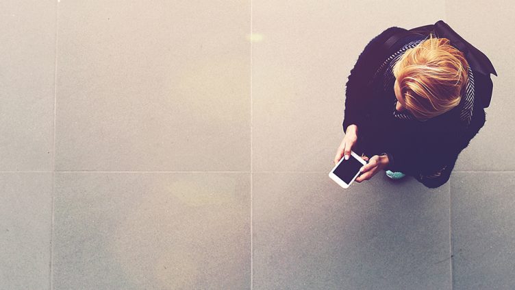 Picture of a woman from the top while using her phone