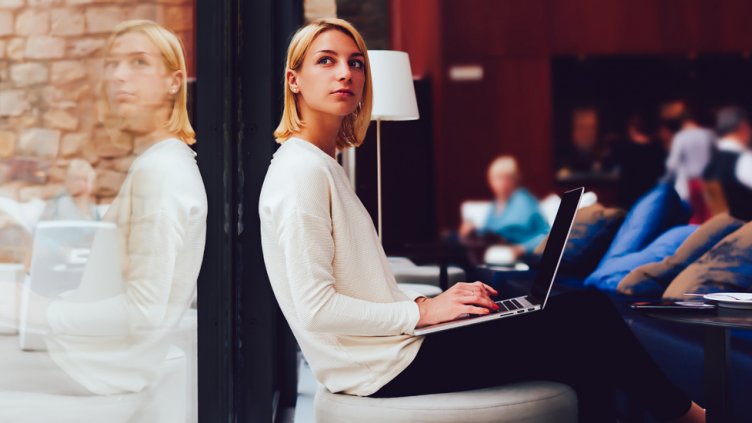 woman thinking while working at café