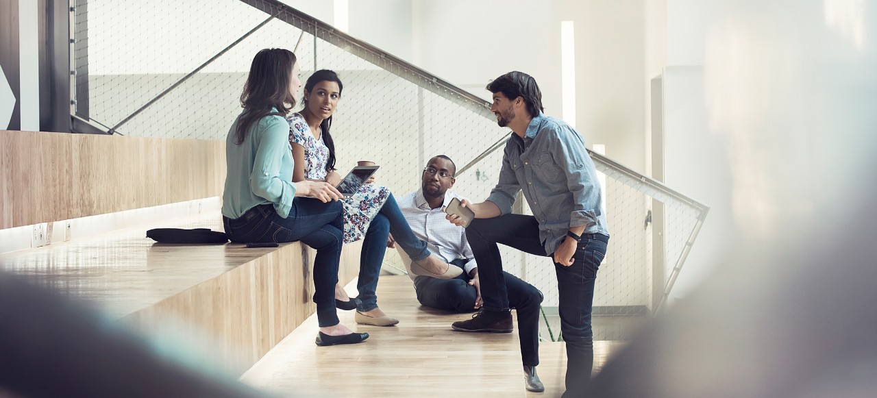 Young business people discussing, sitting on stairs