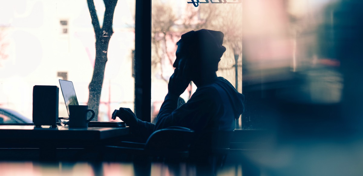 silhouette of man working in café