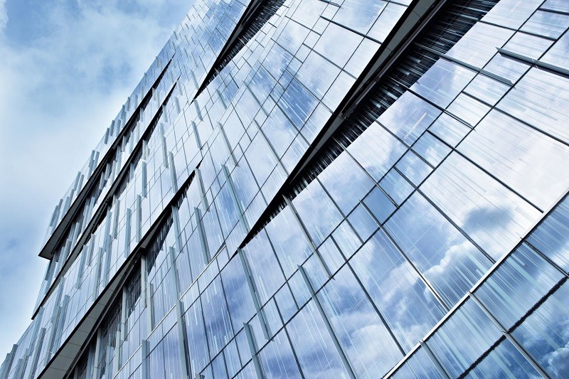 17092568 - corporate building full of glass windows reflecting the sky at afternoon