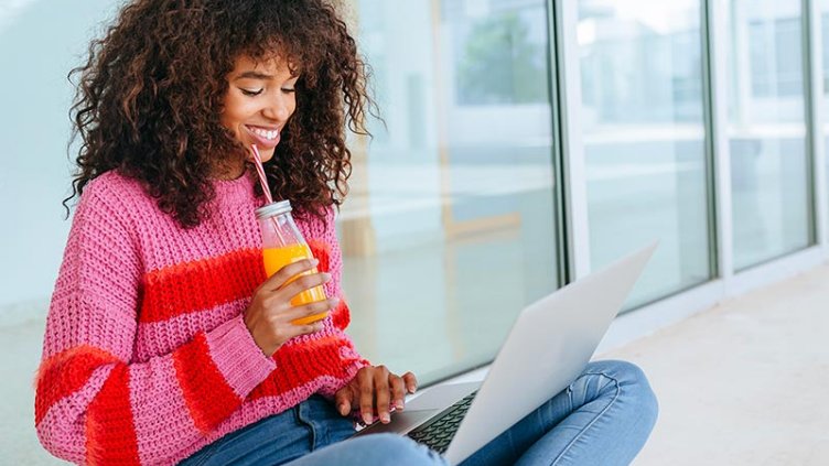 Woman working on laptop on balcony