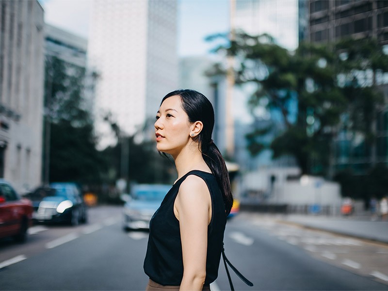 Young woman looking out the office building in the street