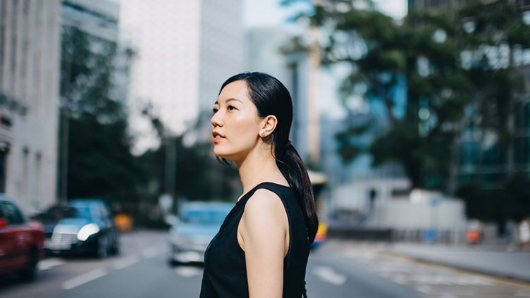 Young woman looking out the office building in the street