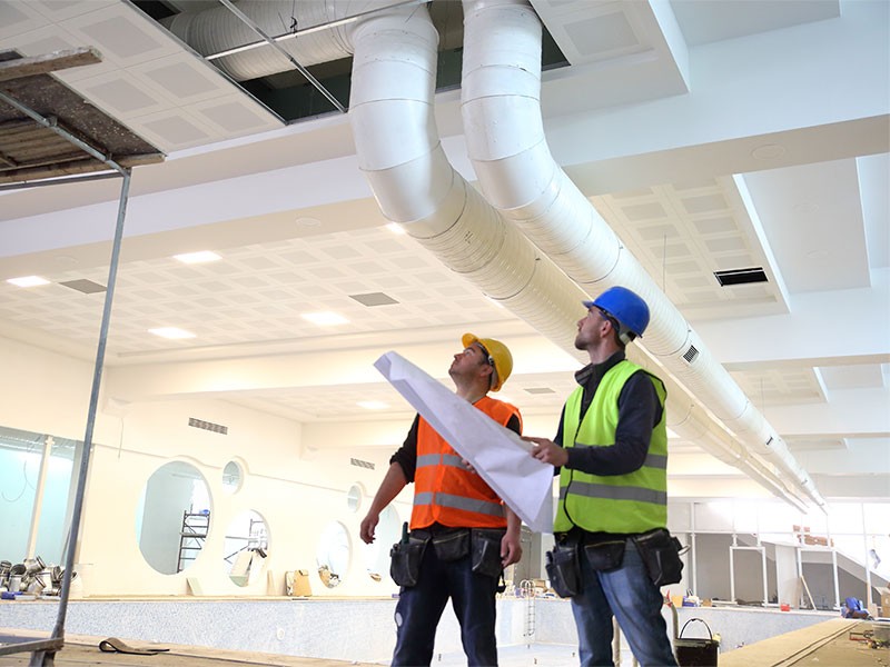 Workers checking the air condition vents in the office