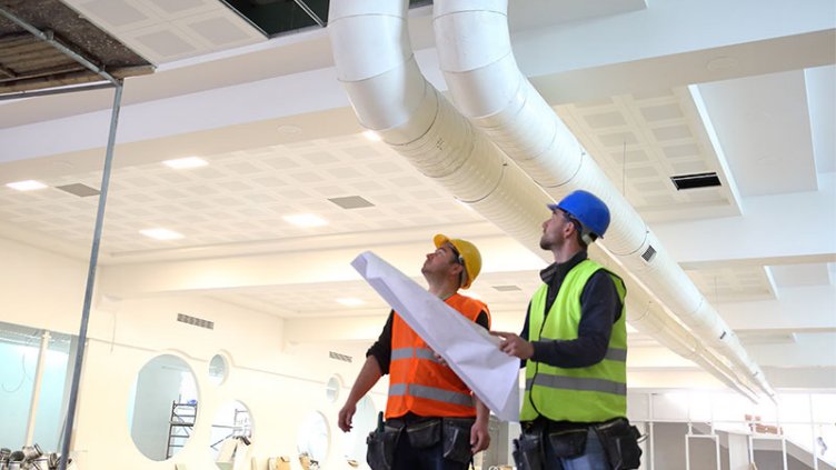 Workers checking the air condition vents in the office