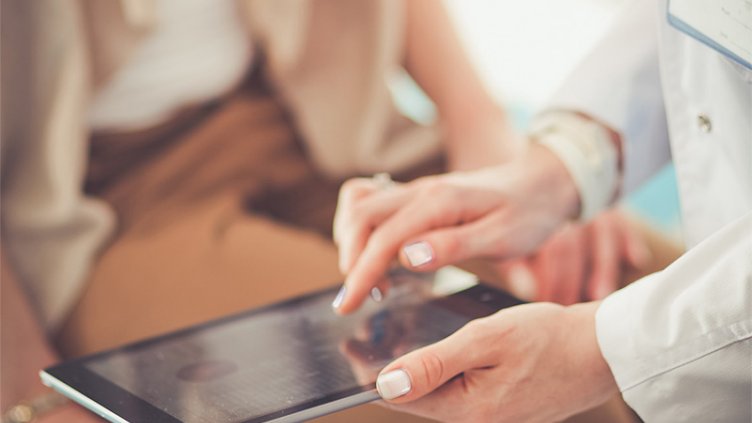 A doctor watching patient's details in her tablet