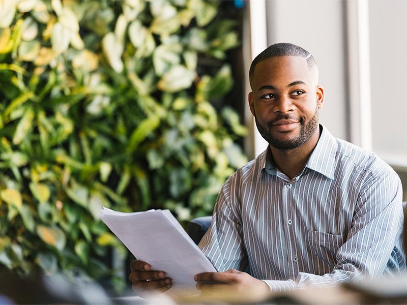 Man smiling at someone while working on some papers