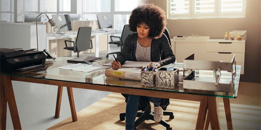 Woman working at a desk and writing on paper