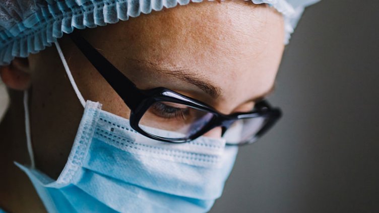 A lady doctor wearing a surgical cap and mask